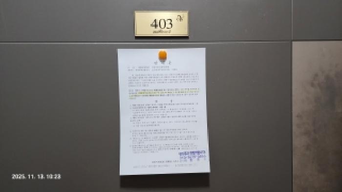 본건 출입문에 부동산경매안내문을 부착